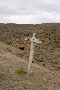 Cross and wrecked car at Quartz Mountain Ghost town.